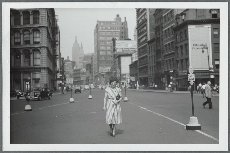 black and white photo of well-dressed woman walking in New York City