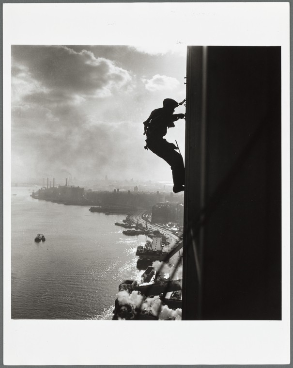 man cleaning UN building windows against New York City backdrop