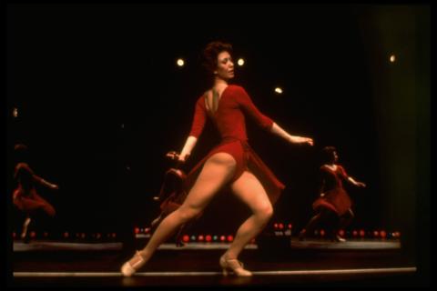 A woman in a red leotard dancing on stage